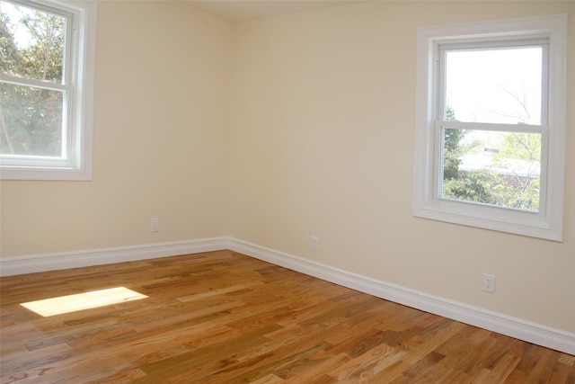 unfurnished room with baseboards and light wood-type flooring