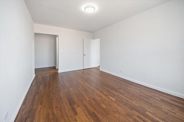 unfurnished room featuring dark wood-type flooring and baseboards
