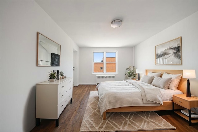 bedroom featuring radiator heating unit and dark wood-style flooring