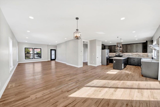 169 Bretton Rd, Yonkers, NY 10710 - unfurnished living room featuring baseboards, recessed lighting, light wood-style flooring, and a notable chandelier