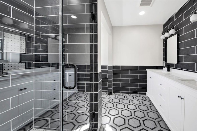 169 Bretton Rd, Yonkers, NY 10710 - bathroom with double vanity, visible vents, tile walls, a stall shower, and recessed lighting