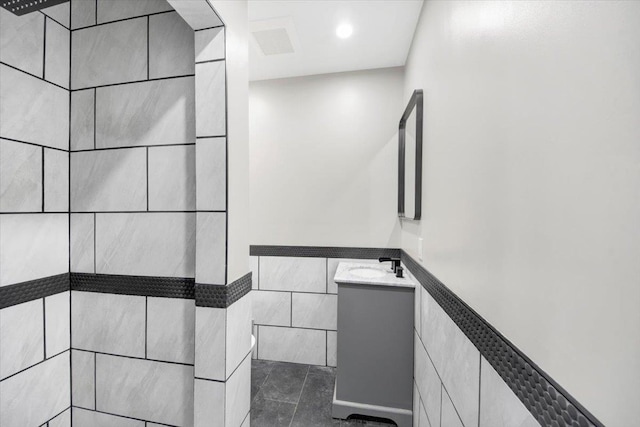 169 Bretton Rd, Yonkers, NY 10710 - stairs featuring tile patterned floors, tile walls, visible vents, and a wainscoted wall