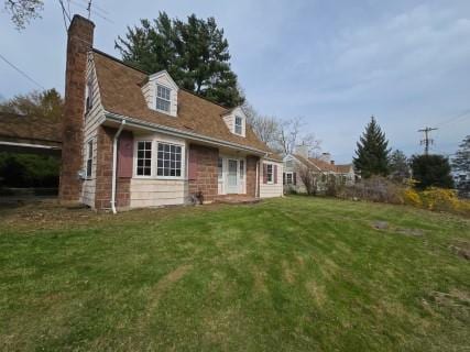 back of property featuring a yard and a chimney