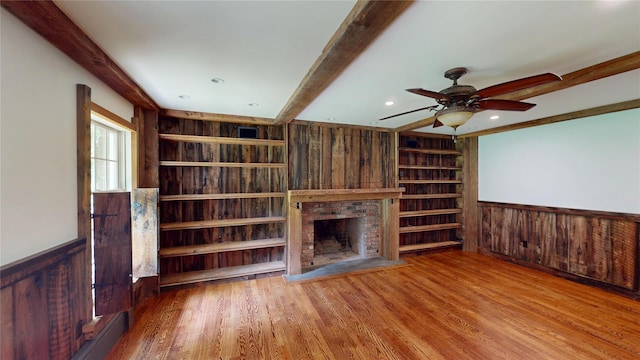11 Hidden Meadow Rd, Warwick, NY 10990 - unfurnished living room with beam ceiling, wood walls, built in shelves, wainscoting, and a fireplace