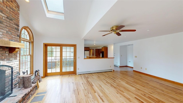11 Hidden Meadow Rd, Warwick, NY 10990 - unfurnished living room featuring a baseboard radiator, a fireplace, light wood finished floors, a ceiling fan, and a skylight