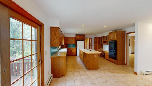 11 Hidden Meadow Rd, Warwick, NY 10990 - kitchen featuring freestanding refrigerator, a center island, light countertops, a baseboard radiator, and brown cabinets