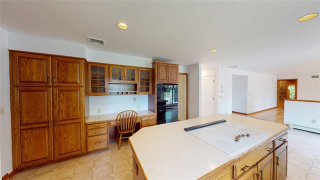 11 Hidden Meadow Rd, Warwick, NY 10990 - kitchen with white electric stovetop, recessed lighting, brown cabinetry, light countertops, and built in desk
