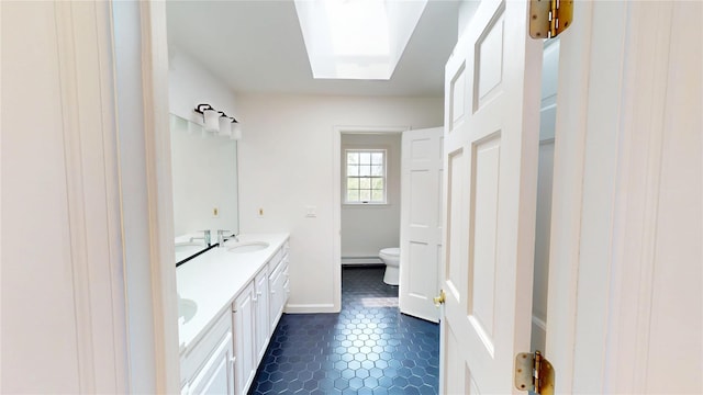 11 Hidden Meadow Rd, Warwick, NY 10990 - full bathroom with double vanity, a skylight, and baseboard heating