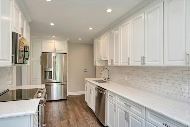 kitchen with baseboards, a sink, appliances with stainless steel finishes, and recessed lighting