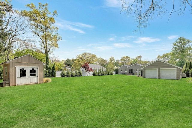 view of yard featuring a garage and an outbuilding