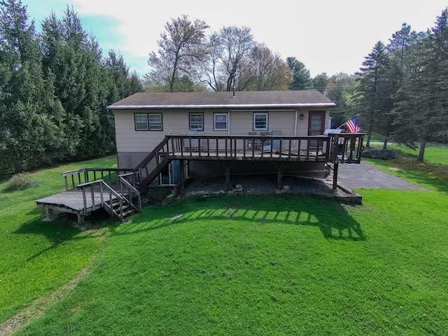 rear view of property featuring stairs, a yard, and a deck
