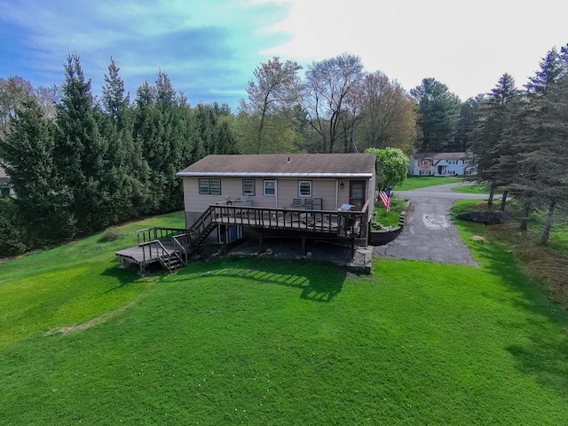back of property featuring a yard, a deck, and stairway