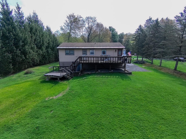 rear view of property featuring a yard and a deck