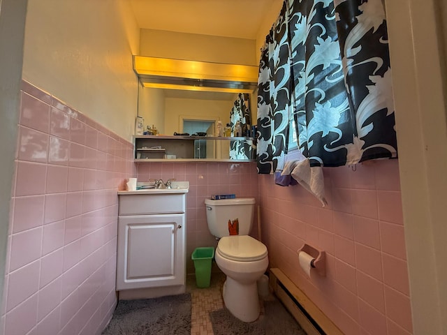 bathroom featuring vanity, toilet, a wainscoted wall, tile walls, and a baseboard radiator