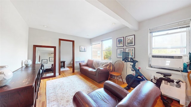 living area with beam ceiling, radiator, cooling unit, and light wood-style floors