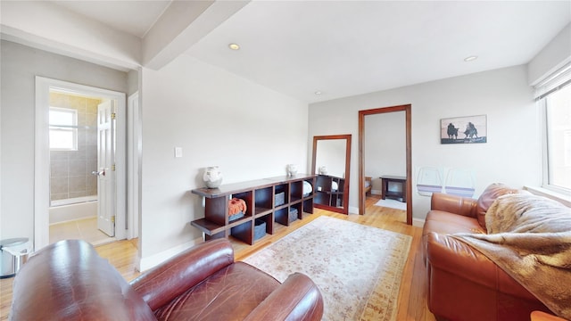 living room featuring plenty of natural light, baseboards, and light wood-type flooring