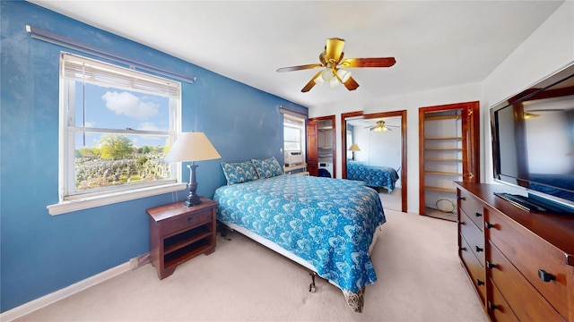bedroom with a ceiling fan, baseboards, multiple closets, and carpet floors