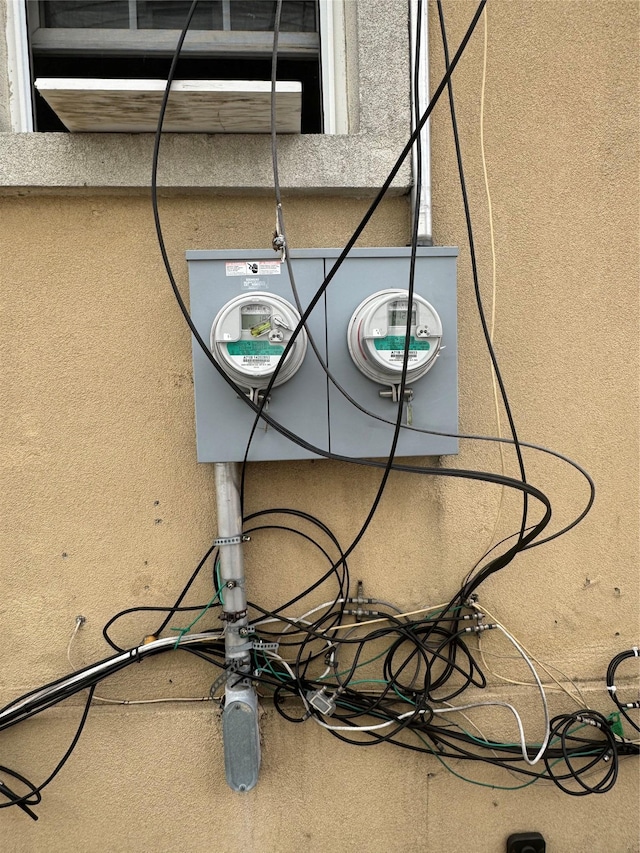 exterior details featuring stucco siding and electric meter
