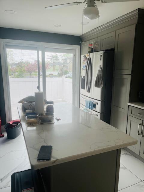 kitchen with a healthy amount of sunlight, refrigerator with ice dispenser, and marble finish floor