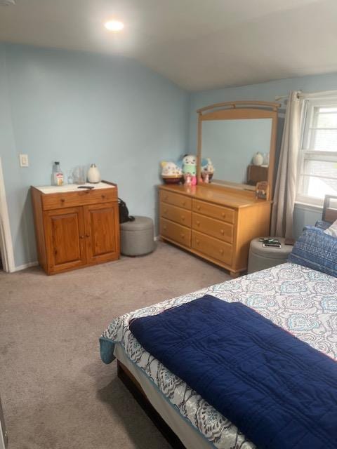 bedroom featuring vaulted ceiling and light carpet