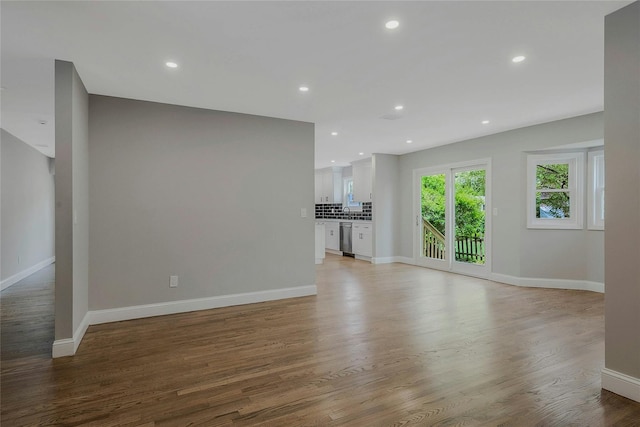 unfurnished living room with baseboards, recessed lighting, and light wood-type flooring