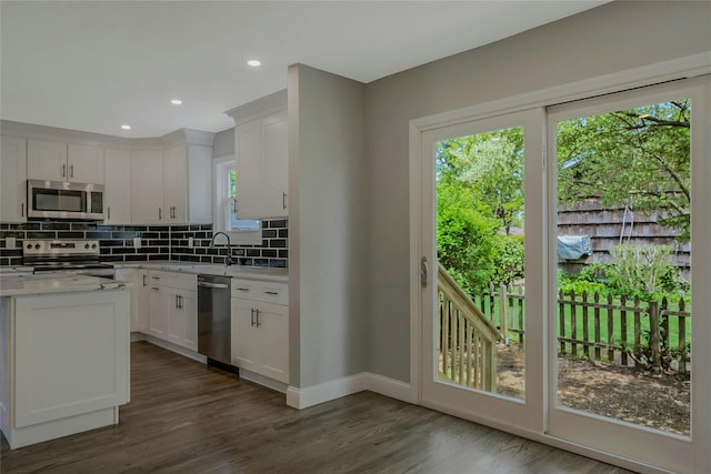 kitchen with baseboards, decorative backsplash, white cabinetry, and appliances with stainless steel finishes