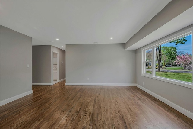 empty room with baseboards, recessed lighting, and wood finished floors