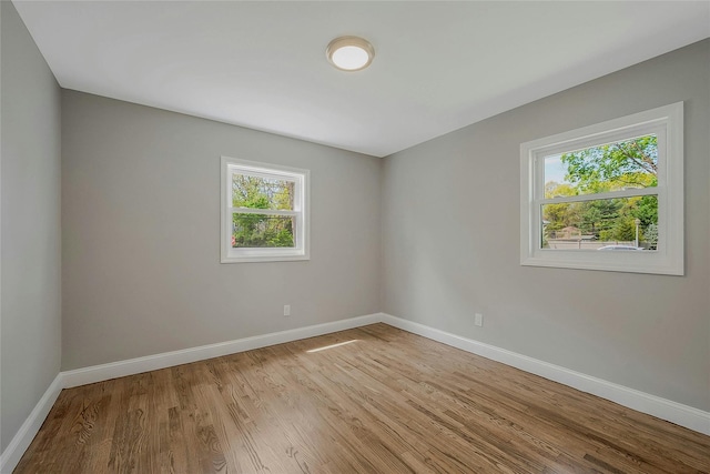 spare room featuring light wood-style floors and baseboards