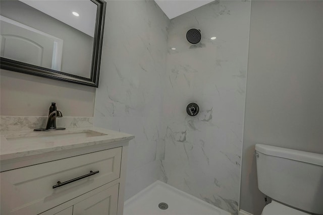 full bath featuring a marble finish shower, vanity, and toilet