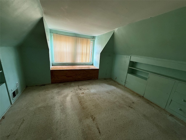 bonus room with vaulted ceiling, carpet flooring, and visible vents