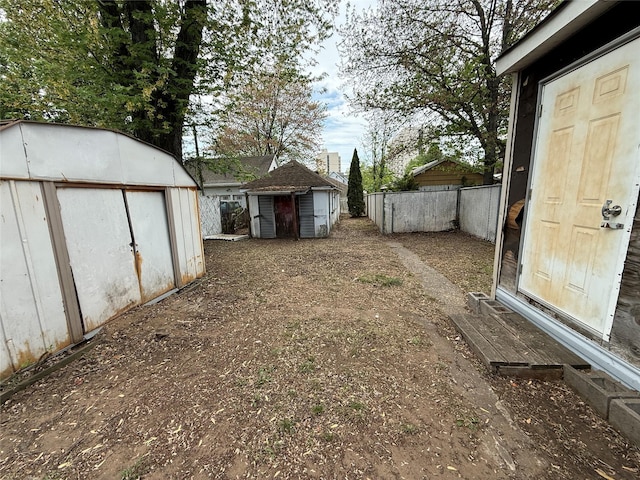 view of yard featuring fence, an outbuilding, and a storage unit