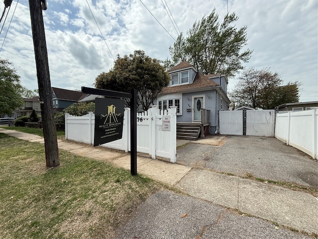 exterior space featuring fence, a gate, and roof with shingles