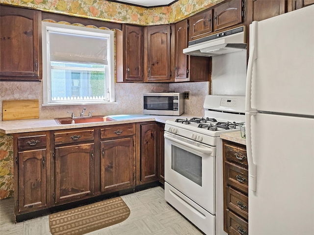 1994 Pine St, North Baldwin, NY 11510 - kitchen featuring white appliances, under cabinet range hood, light countertops, tasteful backsplash, and dark brown cabinetry