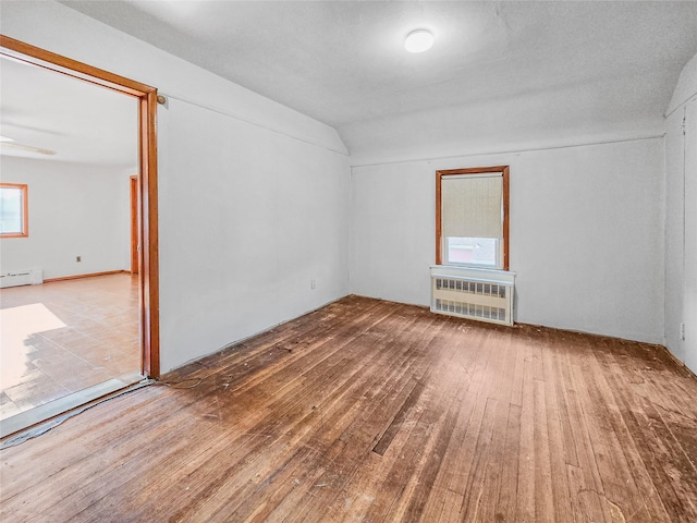 1994 Pine St, North Baldwin, NY 11510 - empty room featuring hardwood / wood-style flooring, a baseboard heating unit, radiator heating unit, lofted ceiling, and ceiling fan