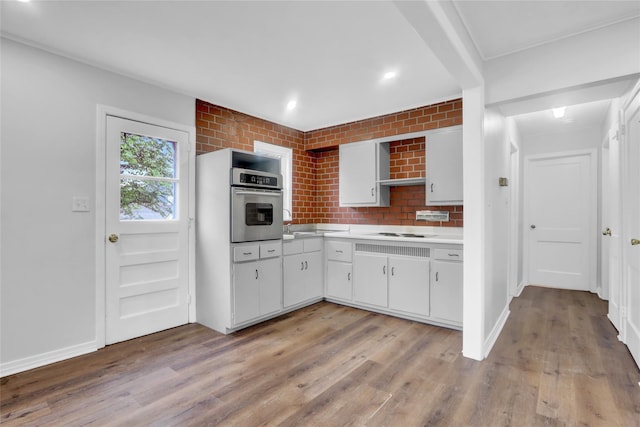 30 Inwood Rd, Glen Cove, NY 11542 - kitchen with stainless steel oven, light countertops, light wood-type flooring, and white cabinets