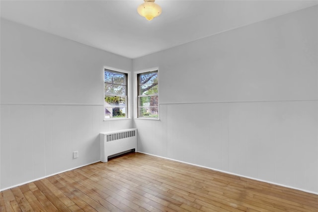 30 Inwood Rd, Glen Cove, NY 11542 - empty room featuring radiator, hardwood / wood-style floors, and a wainscoted wall