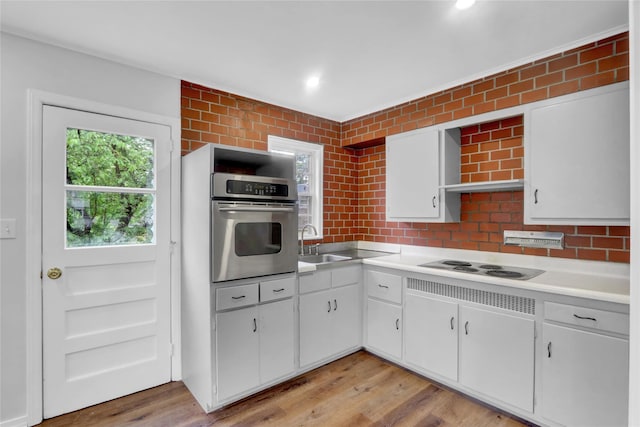 30 Inwood Rd, Glen Cove, NY 11542 - kitchen featuring stainless steel oven, electric stovetop, white cabinets, light countertops, and light wood-type flooring