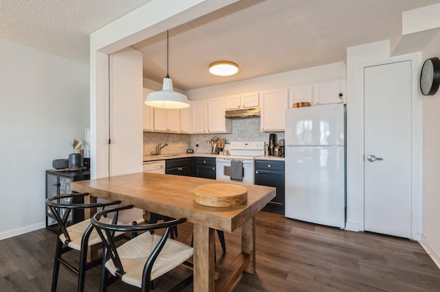 260 Bch 81st St Unit 5T, Rockaway Beach, NY 11693 - kitchen featuring decorative backsplash, dark wood finished floors, a sink, under cabinet range hood, and white appliances