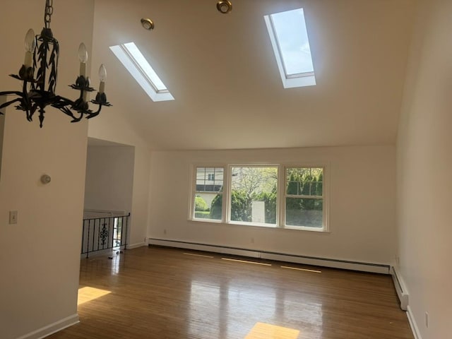 unfurnished living room with baseboards, a baseboard heating unit, wood finished floors, and lofted ceiling with skylight