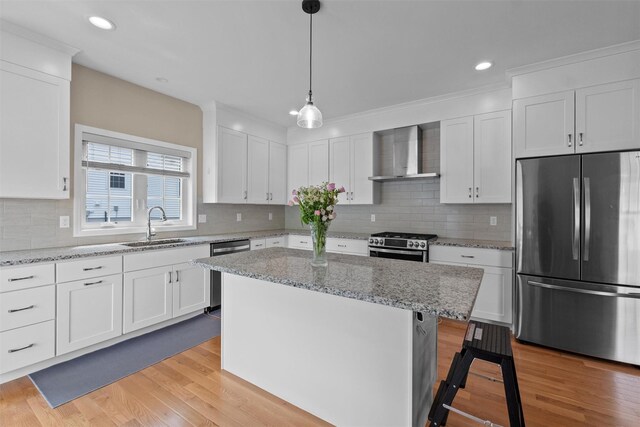 32 N Ridge Rd, Mahopac, NY 10541 - kitchen featuring appliances with stainless steel finishes, wall chimney exhaust hood, a sink, light wood finished floors, and white cabinetry