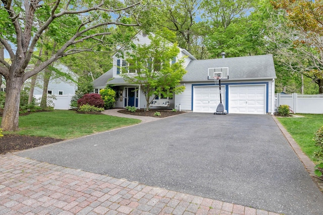 view of front of house featuring asphalt driveway, a garage, and roof with shingles