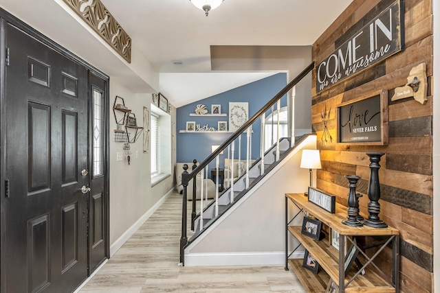 foyer featuring plenty of natural light, baseboards, stairs, and vaulted ceiling