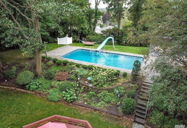 pool with a water slide and a yard