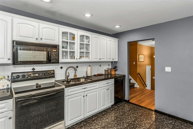 31 Elmwood Ct, Plainview, NY 11803 - kitchen with black appliances, a sink, dark countertops, glass insert cabinets, and white cabinets