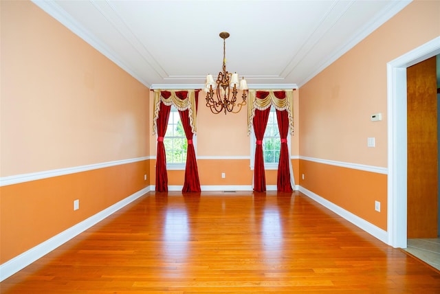 unfurnished dining area featuring baseboards, an inviting chandelier, ornamental molding, and light wood-style flooring