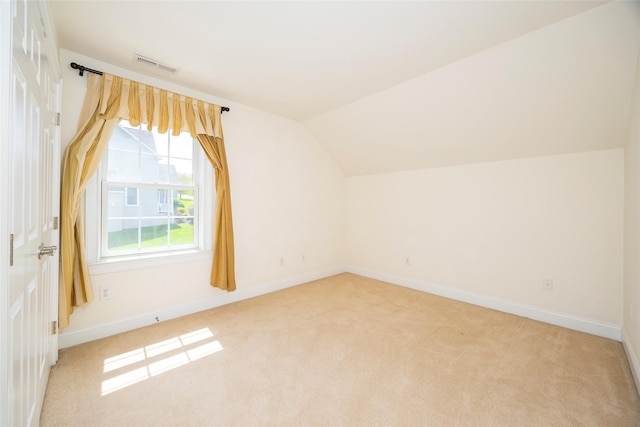 bonus room featuring visible vents, light carpet, and vaulted ceiling