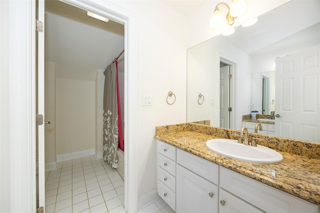 full bath featuring vanity, baseboards, and tile patterned floors