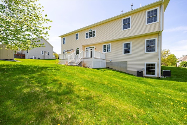 back of house with a lawn, central AC unit, and a deck