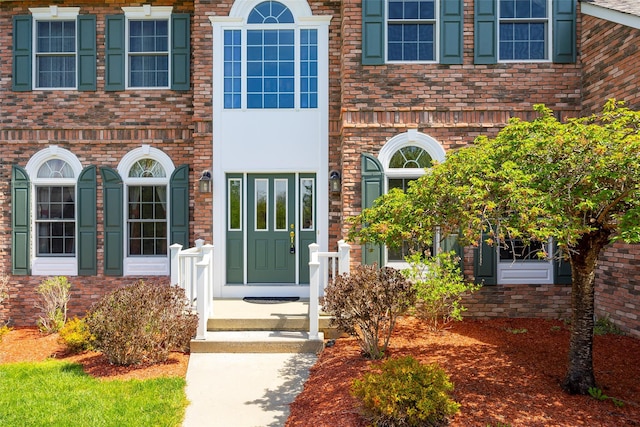 view of exterior entry with brick siding