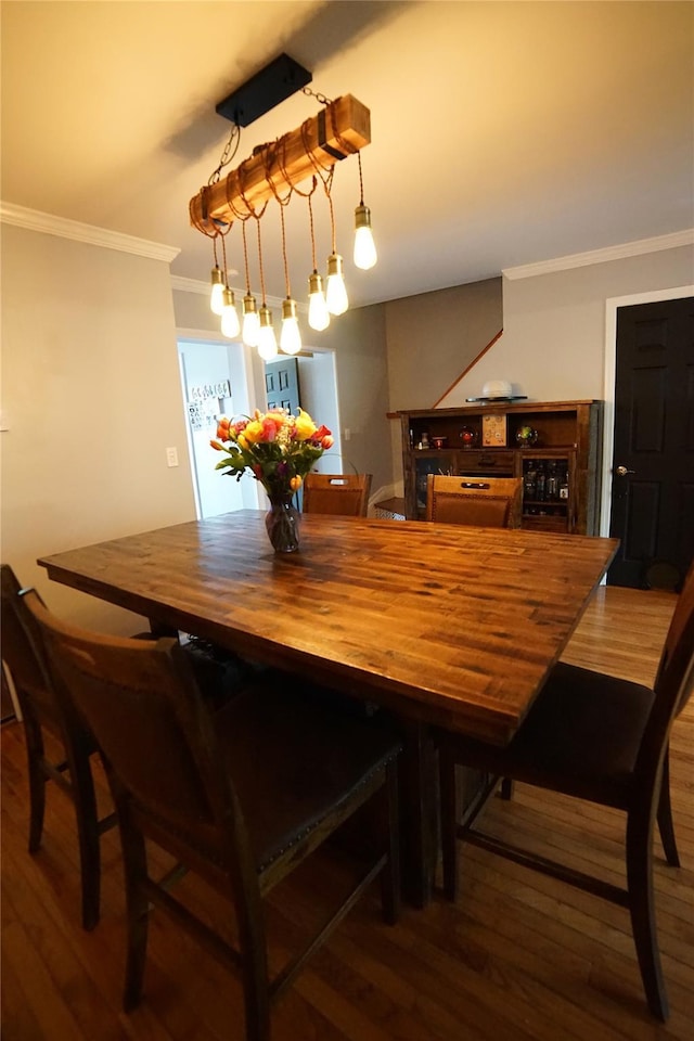 dining space with crown molding and wood finished floors